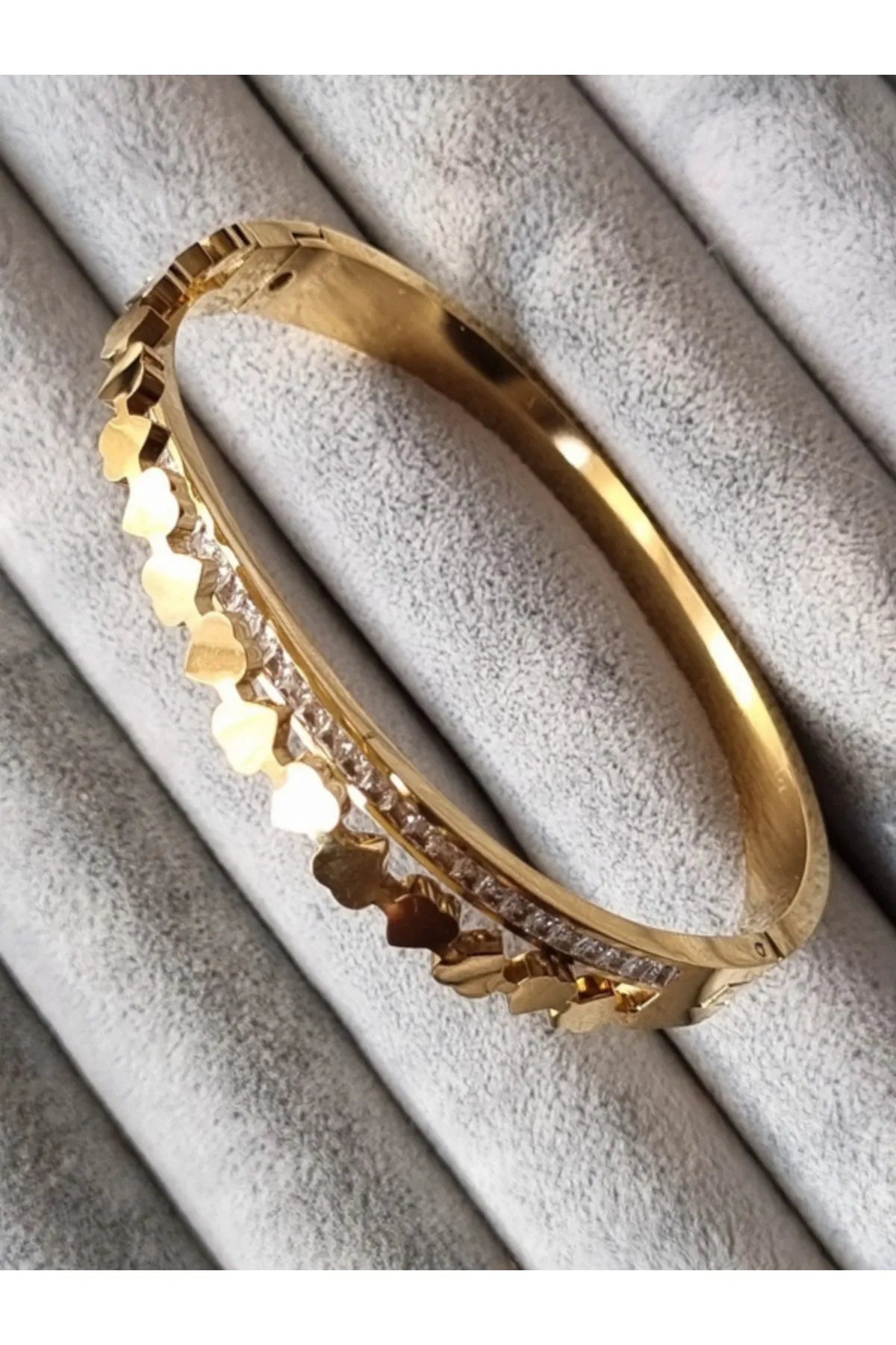 A golden cuff bracelet with Roman numerals and small crystals.