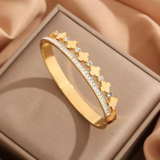 A golden cuff bracelet with Roman numerals and small crystals.